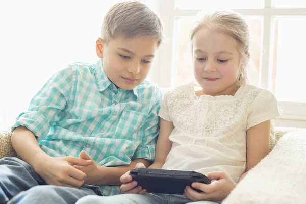 Geschwister spielen Videospiel mit der Hand — Stockfoto
