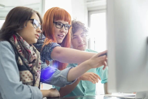 Colleagues discussing over computer — Stock Photo, Image