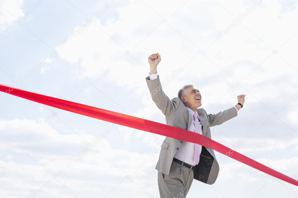 Businessman crossing finish line