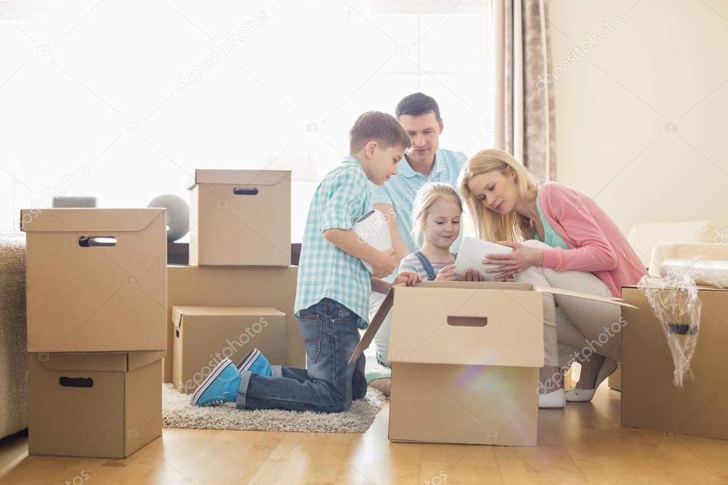 Family unpacking cardboard boxes