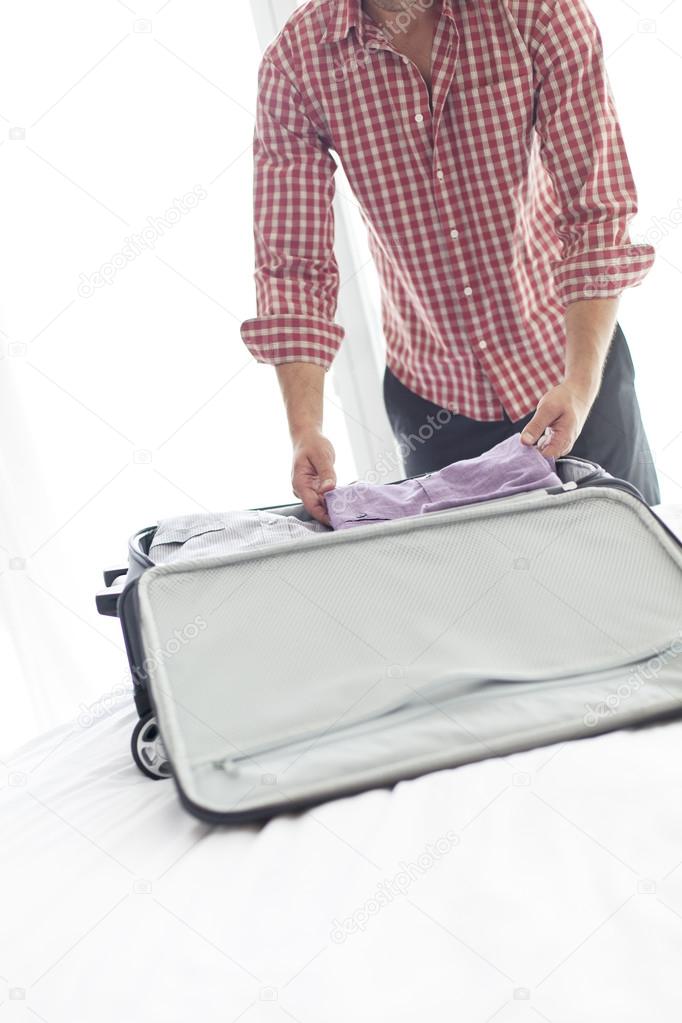 Businessman packing suitcase