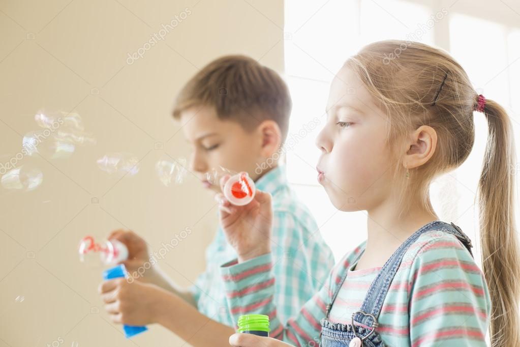 Brother and sister playing with bubble wands