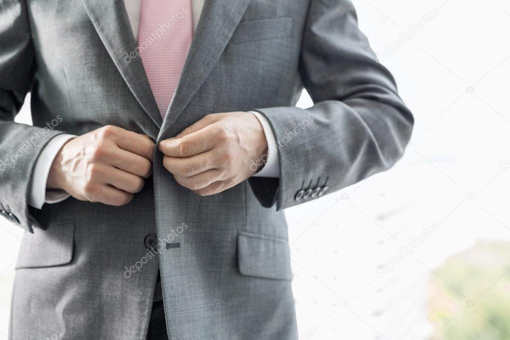 Businessman buttoning his blazer