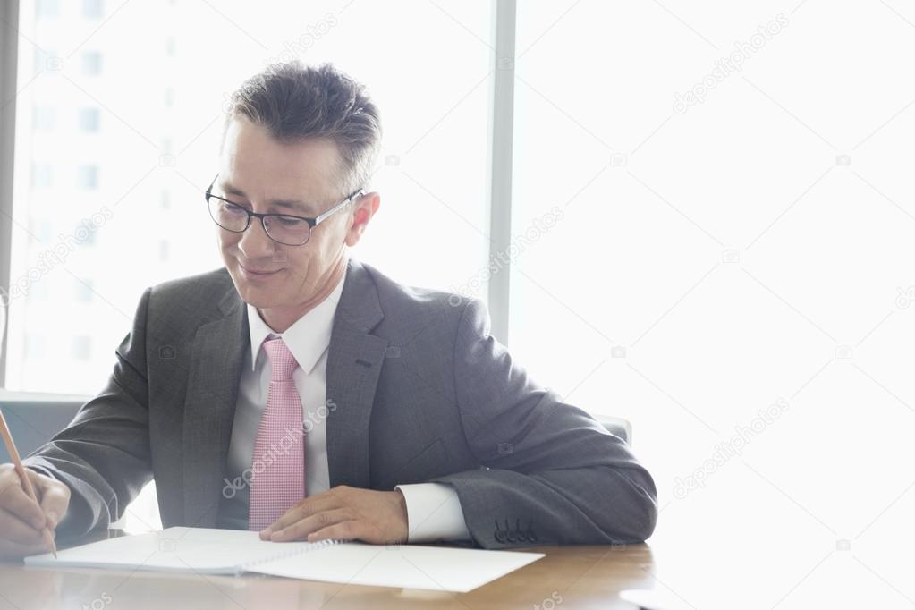 Mature businessman writing