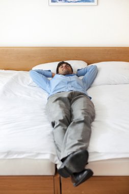 Otel odasında uyuyan işadamı