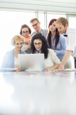 Meslektaşları dizüstü bilgisayar kullanarak