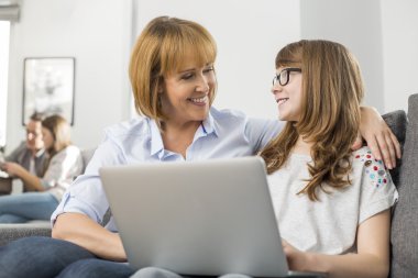 Annesi ve kızı dizüstü bilgisayarlı.