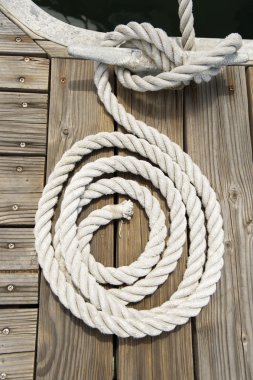 Rope of boat tied to a jetty cleat clipart