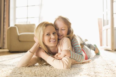 mother with daughter lying on floor clipart
