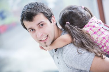 Adam küçük kızı piggybacking