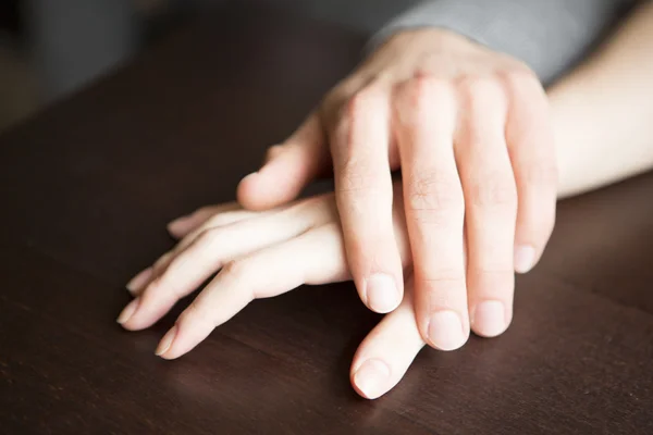 Manos de pareja en la mesa — Foto de Stock