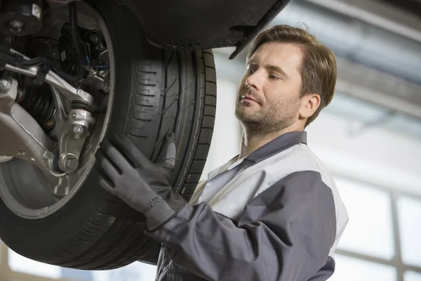 Técnico ajustando el neumático del coche — Foto de Stock