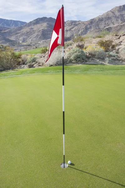 Bola de golfe e bandeira — Fotografia de Stock