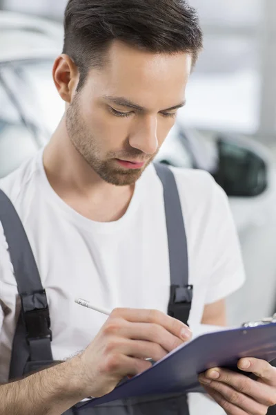 Maintenance engineer writing on clipboard — Stock Photo, Image