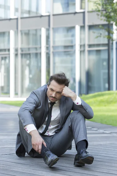 Businessman sitting on path — Stock Photo, Image