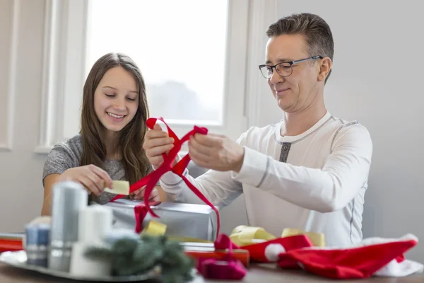 父と娘のクリスマス プレゼントをラッピング — ストック写真