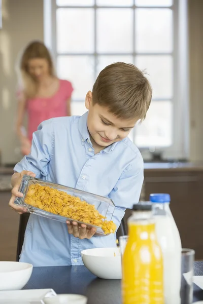 Ragazzo versando corn flakes in ciotola — Foto Stock