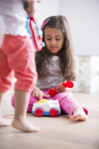 Menina bonito discando o telefone do brinquedo — Fotografia de Stock