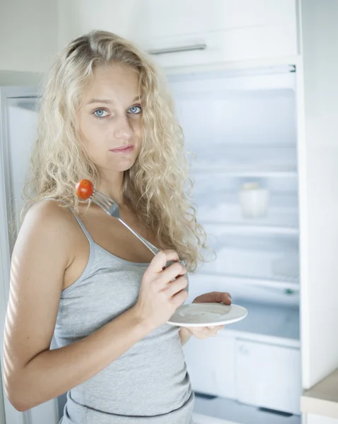 Sad woman having cherry tomato — Stock Photo, Image