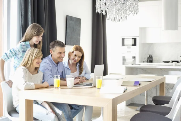 Familj på fyra använder laptop — Stockfoto