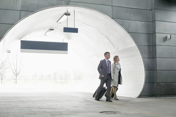 Businessman and businesswoman entering station — Stock Photo, Image
