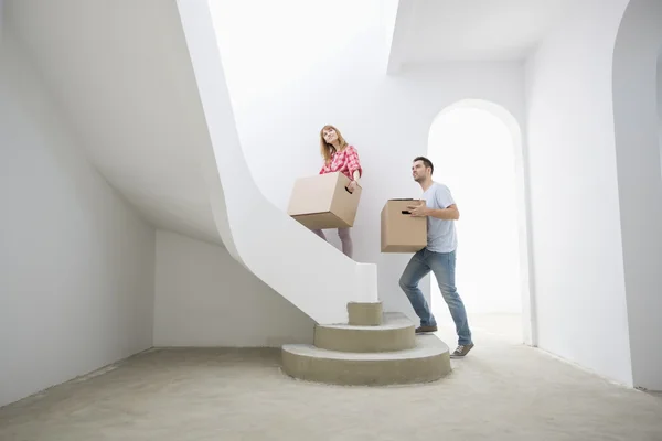 Couple carrying boxes up stairs — Stock Photo, Image