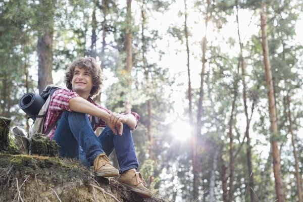 Smiling male hiker sitting on cliff — Stock Photo, Image