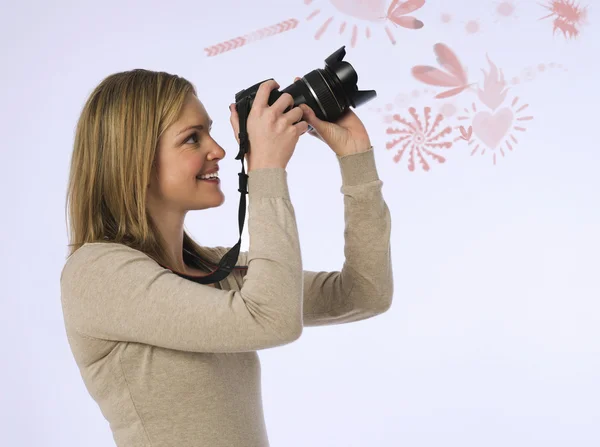 Vrouwelijke fotograaf met camera in studio — Stockfoto