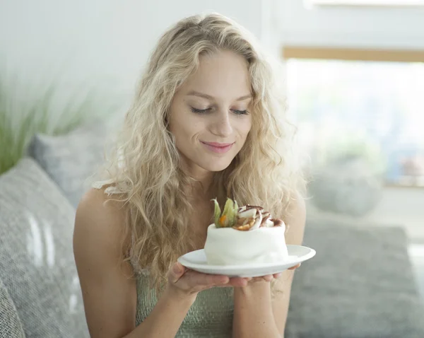 Vrouw die kijkt verleidelijk taart — Stockfoto