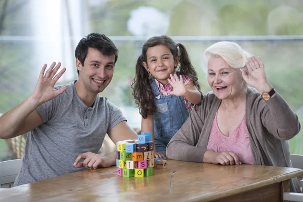 Kvinna med son och barnbarn viftande händer — Stockfoto