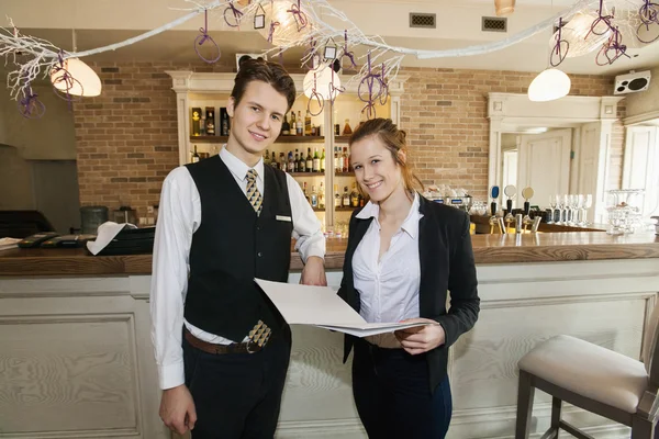 Waiter and waitress standing in restaurant — Stock Photo, Image