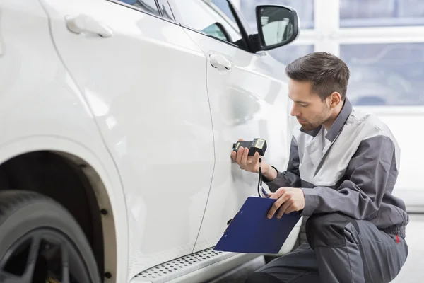 Réparateur examinant la peinture de voiture — Photo