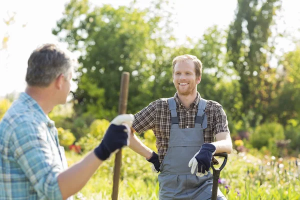 Gardeners talking at plant nursery — Stock Photo, Image