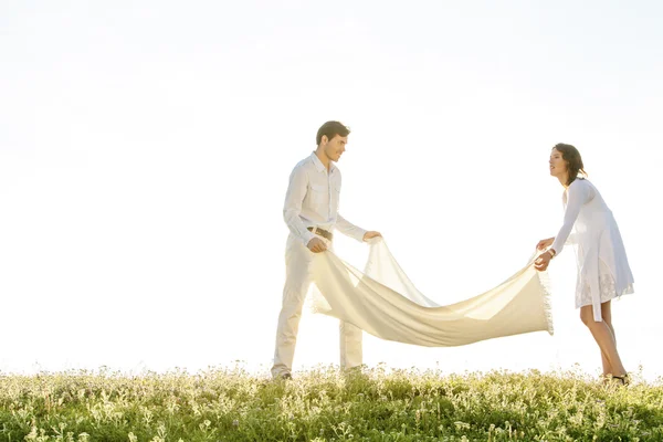 Frau und Mann breiten Picknickdecke aus — Stockfoto