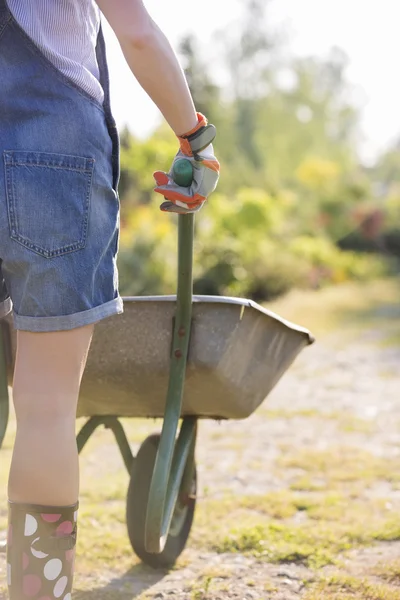Pchania taczki kobiece ogrodnik — Zdjęcie stockowe