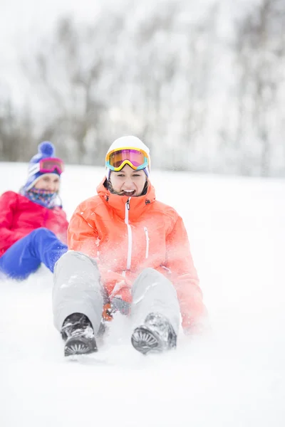 Women enjoying sled ride in snow — Stock Photo, Image