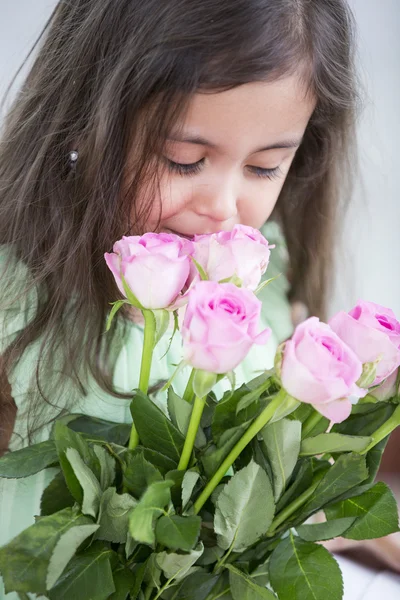 Girl smelling roses — Stock Photo, Image