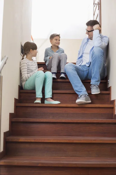 Vader zittend met kinderen op stappen — Stockfoto