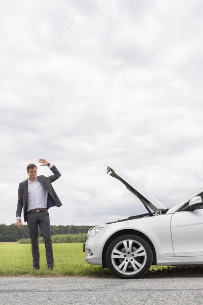 Young businessman waving for help — Stock Photo, Image