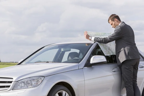 Businessman reading map — Stock Photo, Image