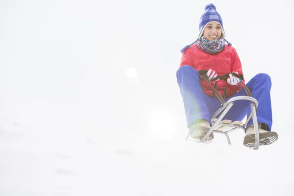 Vrouw sleetje rijden in de sneeuw — Stockfoto