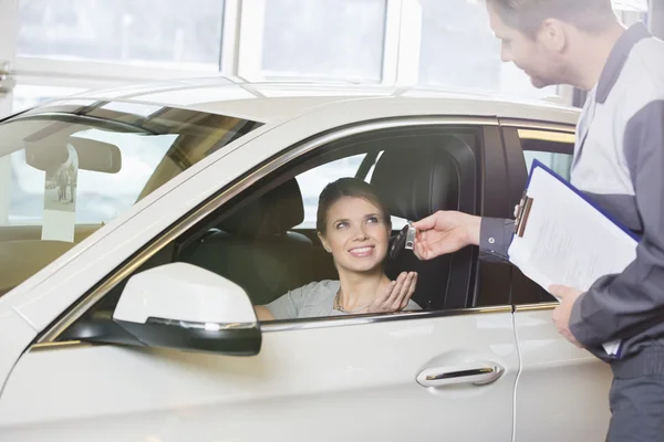 Vrouwelijke klant ontvangende auto ke — Stockfoto