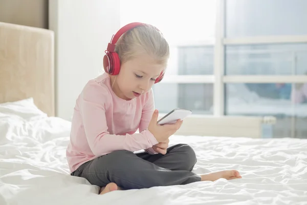 Flicka lyssnar på musik på hörlurar — Stockfoto