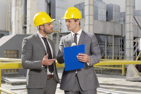 Engineers with clipboard discussing — Stock Photo, Image