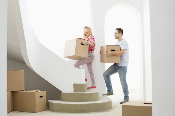 Couple carrying boxes up stairs — Stock Photo, Image