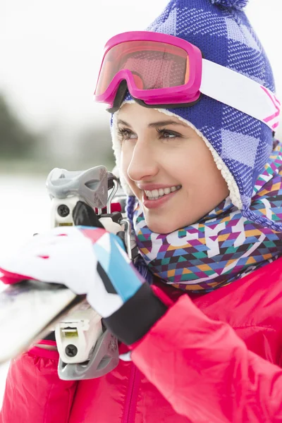 Jeune femme portant des skis — Photo