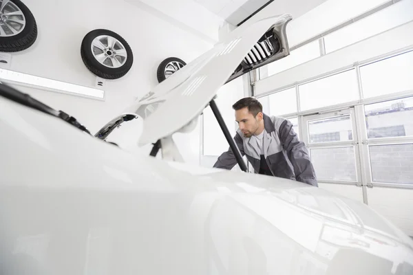 Mecánico de automóvil examinando el motor del coche — Foto de Stock