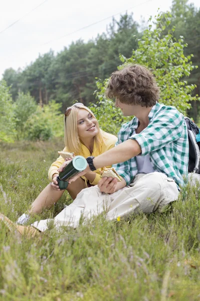 Male hiker pouring coffee for woman — Stock Photo, Image