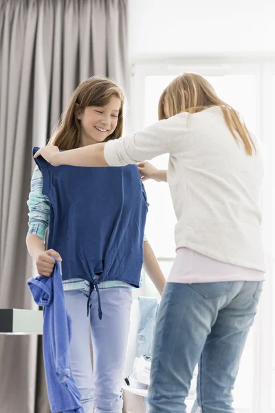 Sisters trying on clothes — Stock Photo, Image