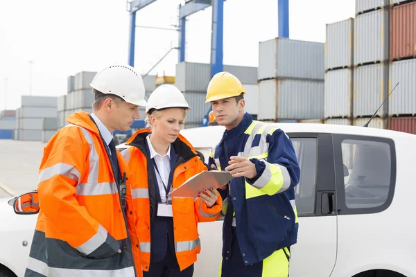 Trabajadores discutiendo sobre portapapeles — Foto de Stock